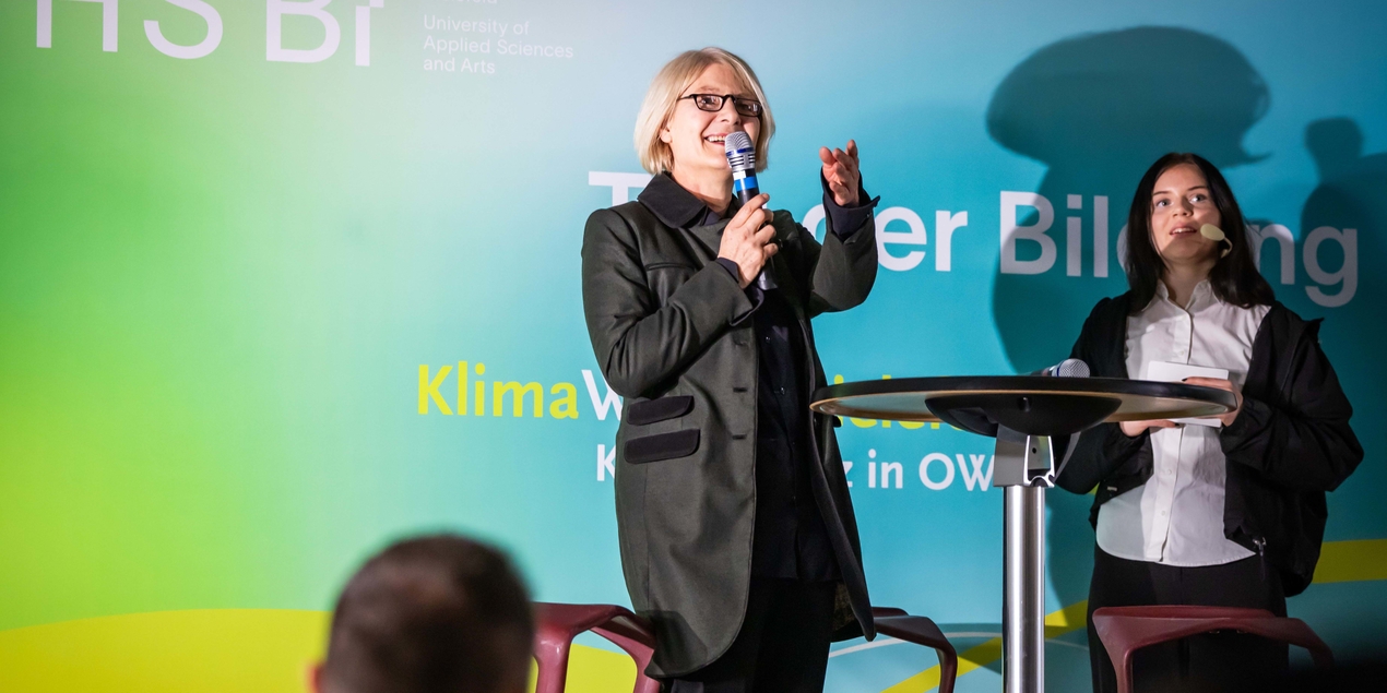 Ingeborg Schramm-Wölk spricht auf der Bühne in ein Mikrofon
