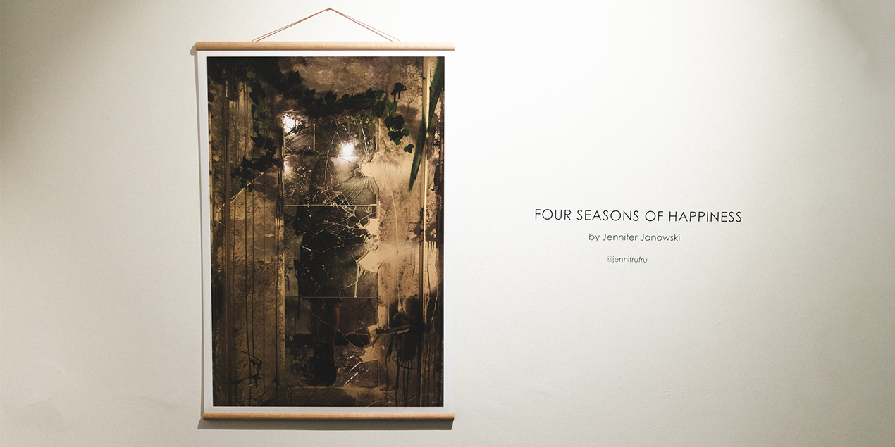 An einer weißen Wand hängt eine Fotografie von Jennifer Janowski daneben steht der Titel ihrer Ausstellung four seasons of happiness