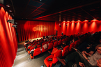 Filmfestival DMX FOR Ein voll besetzer Kinosaal im Lichtwerk aus der letzten Reihe fotografiert. Der Vorhang is tnoch geschlossen.
